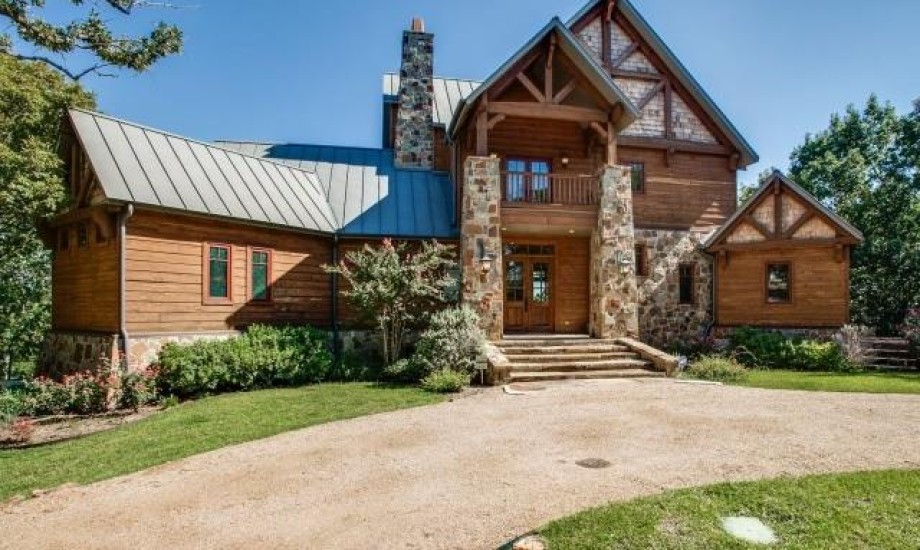A large log home in the woods.