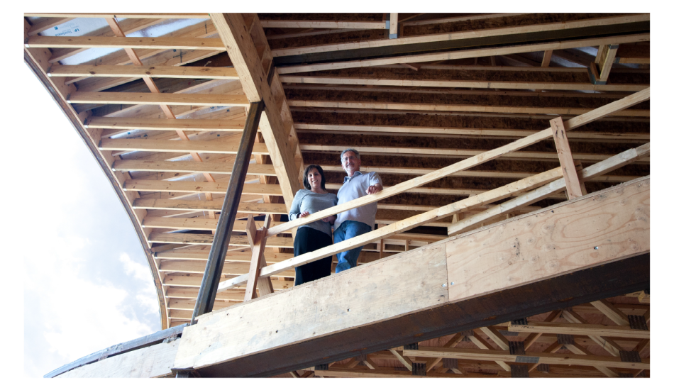 Two people standing on the top of a wooden structure.