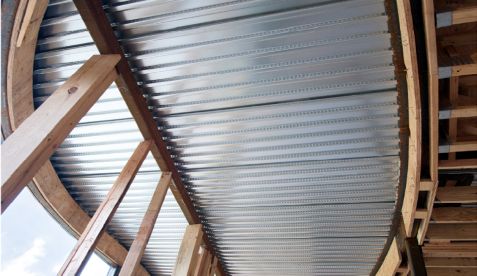 The ceiling of a house is being built with corrugated metal.