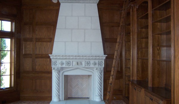 Ornate carved fireplace in wood-paneled library