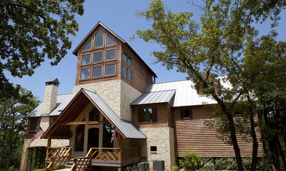 A home with a wooden deck and a metal roof.