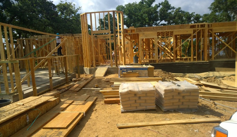Wood-frame house under construction with stacked lumber