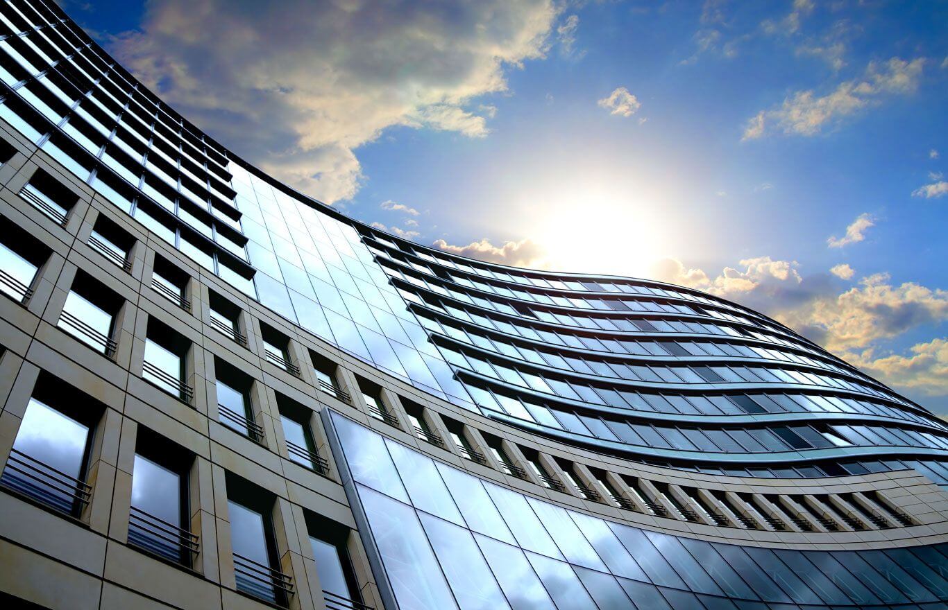An office building with a blue sky behind it.
