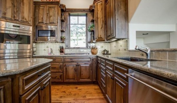 A kitchen with wooden cabinets and counter tops.