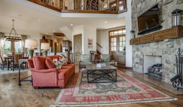 A living room with a stone fireplace and a stone staircase.